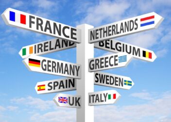 European travel destinations signpost. A signpost points towards various European countries, including France, Netherlands, Ireland, Germany, Spain, Greece, Sweden, UK, and Italy, representing travel options for digital nomads.