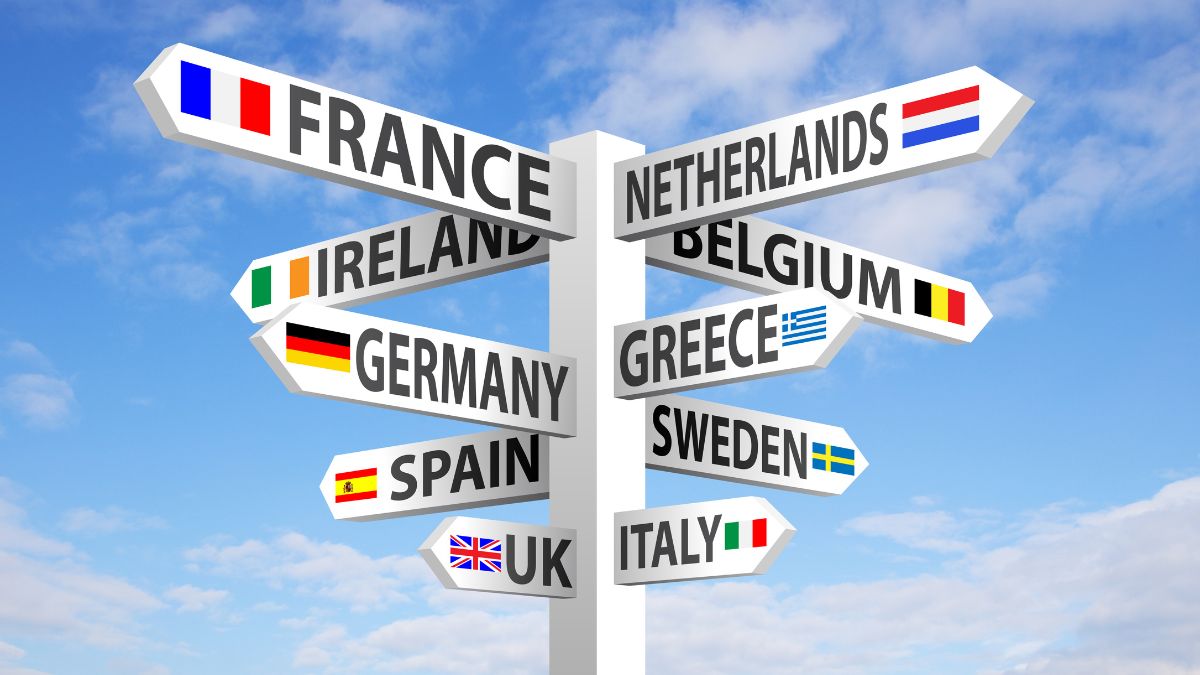 European travel destinations signpost. A signpost points towards various European countries, including France, Netherlands, Ireland, Germany, Spain, Greece, Sweden, UK, and Italy, representing travel options for digital nomads.