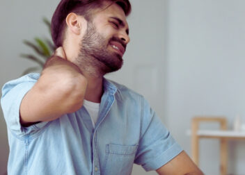 Person with wry neck holding their neck in discomfort, showing twisted head and stiff posture