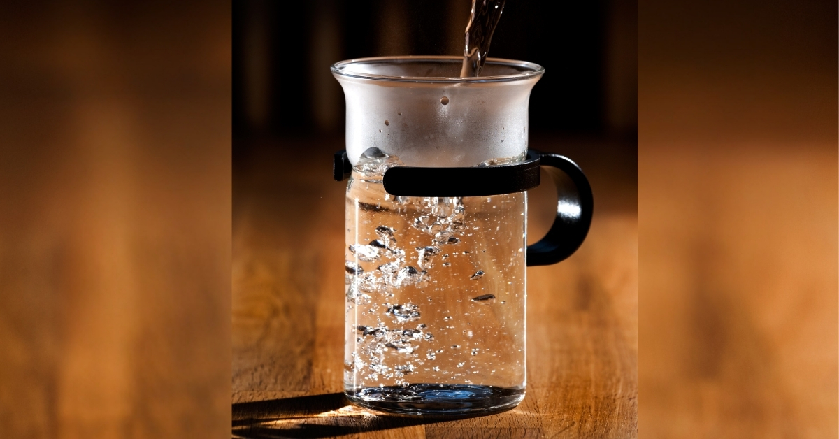 Glass of steaming hot water on a kitchen counter, representing the Ayurvedic practice of Ushnodaka for health and longevity