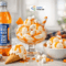 Chilled IRN-BRU Zero bottle beside creamy vanilla ice cream with orange drizzle and marshmallow topping in a bright studio-style setting