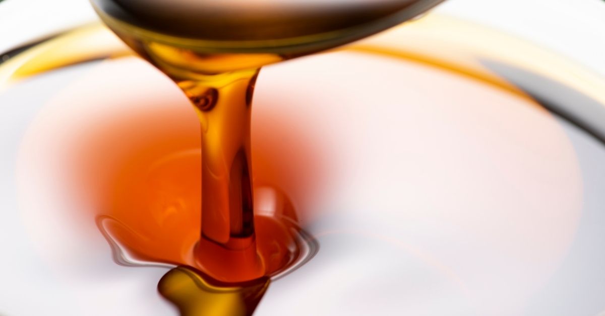 Golden sesame oil in a bowl with sesame seeds – Tila Tailam for hair, skin, and wellness